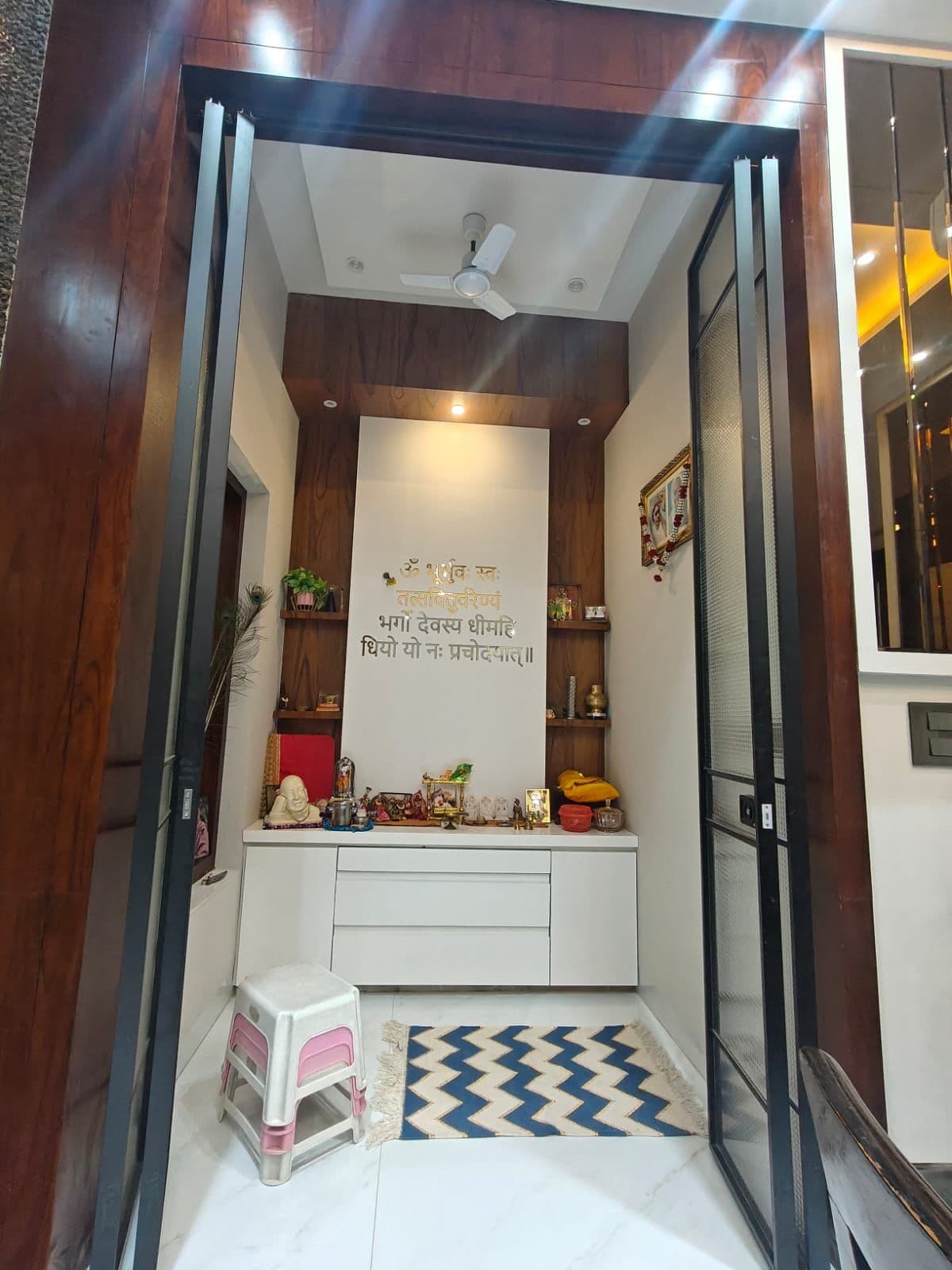 Puja room — wood-panelled walls with the Gayatri Mantra in brass