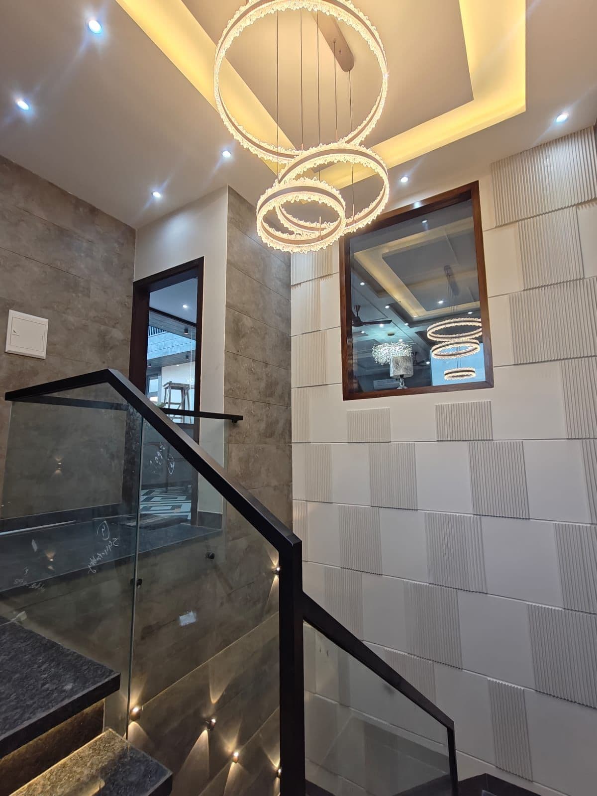 Stairwell with twin-ring crystal chandelier and 3D-fluted wall panels